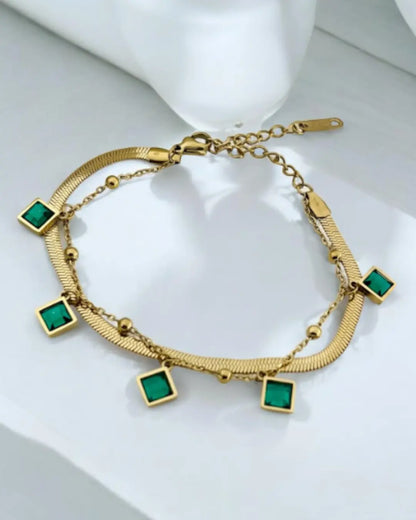 gold-plated bracelet featuring emerald-green charms